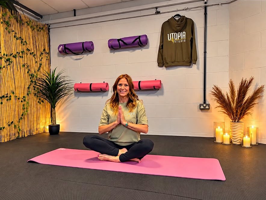 The Utopia Gym studio set up for a yoga class, with mats, plants and candlelight